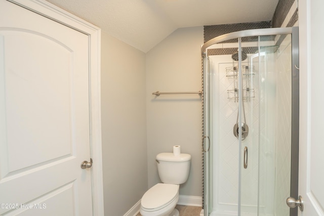 bathroom featuring a textured ceiling, an enclosed shower, lofted ceiling, and toilet