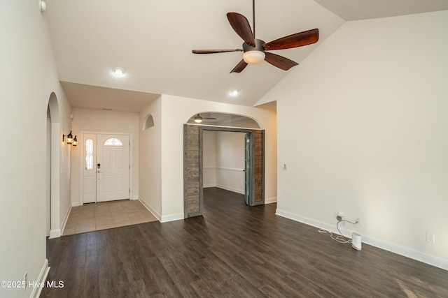 foyer entrance with ceiling fan, lofted ceiling, and dark wood-type flooring