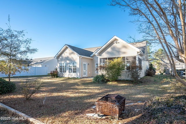 ranch-style house featuring a fire pit and a front lawn