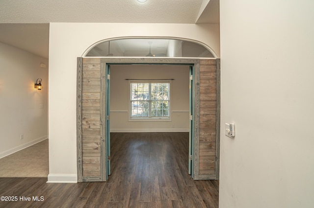 interior space with a textured ceiling and dark hardwood / wood-style floors