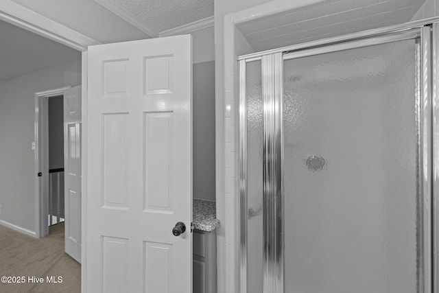 bathroom featuring a textured ceiling, walk in shower, and crown molding