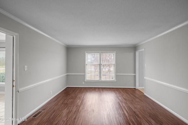 spare room featuring a textured ceiling, dark hardwood / wood-style floors, and ornamental molding