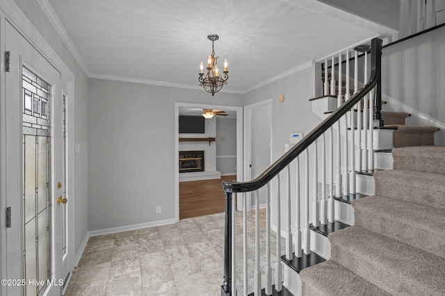 staircase with a chandelier, a textured ceiling, and ornamental molding