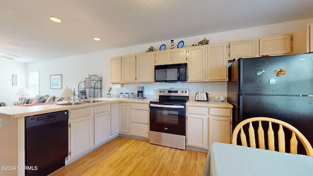 kitchen featuring sink, kitchen peninsula, light hardwood / wood-style floors, a textured ceiling, and black appliances