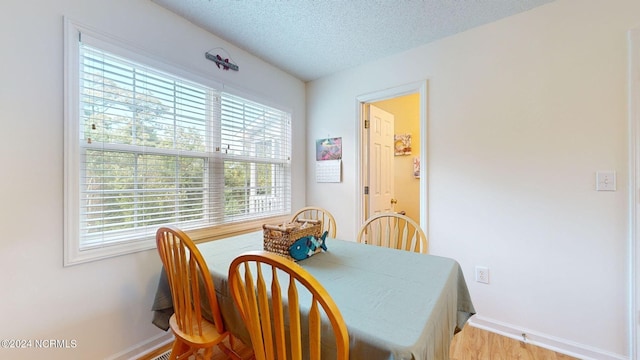 dining room with a textured ceiling and light hardwood / wood-style floors