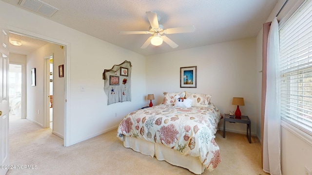 carpeted bedroom featuring multiple windows and ceiling fan