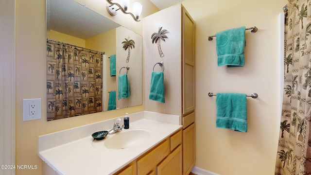 bathroom with vanity, curtained shower, and a textured ceiling