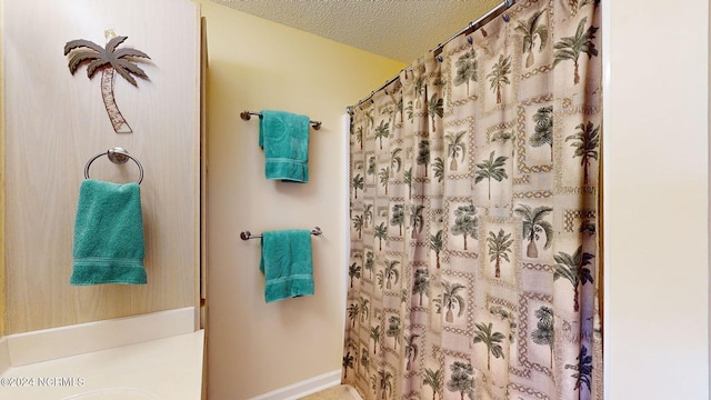 bathroom with a shower with curtain and a textured ceiling