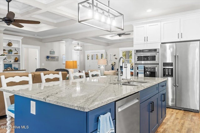 kitchen featuring a sink, ornamental molding, ceiling fan, stainless steel appliances, and blue cabinets