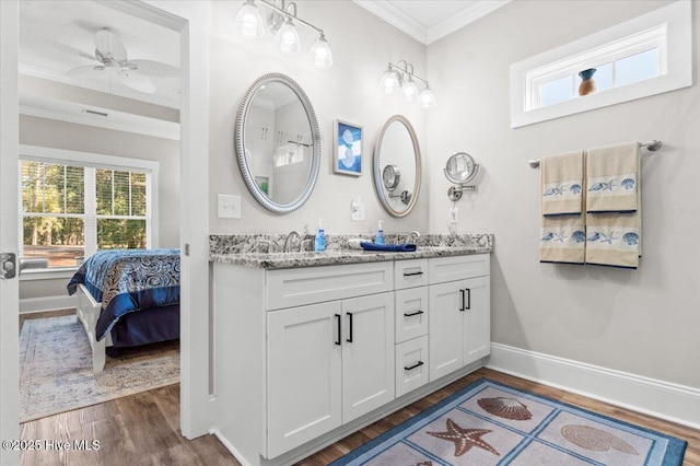 full bathroom with baseboards, a healthy amount of sunlight, wood finished floors, and crown molding