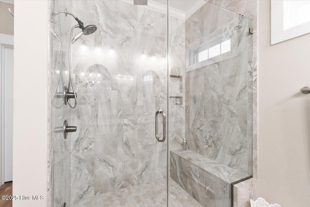 bathroom featuring a marble finish shower and ornamental molding