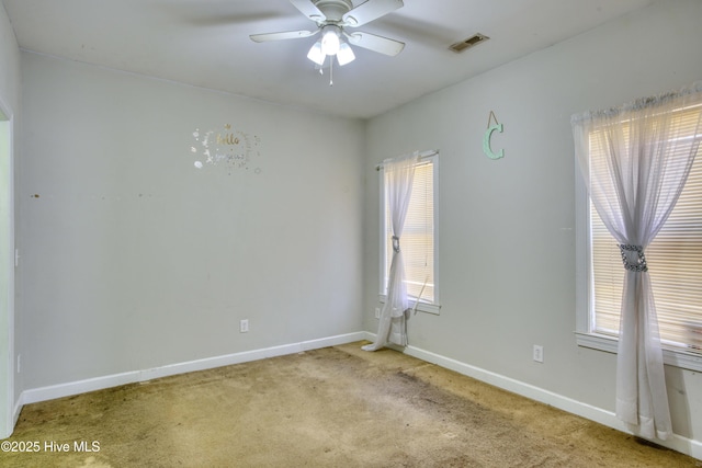 empty room featuring ceiling fan and light carpet