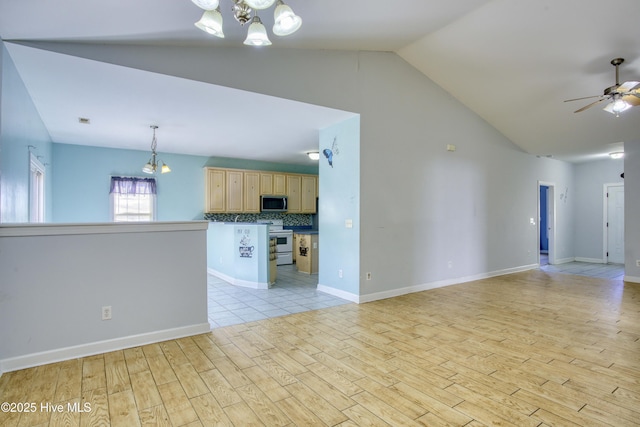 unfurnished living room featuring vaulted ceiling, ceiling fan with notable chandelier, and light wood-type flooring