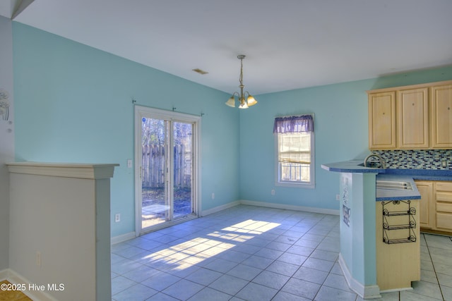 unfurnished dining area with a notable chandelier, sink, and light tile patterned flooring