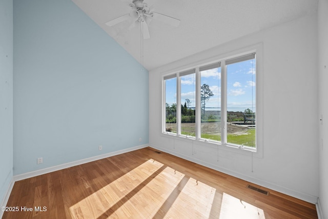 unfurnished room featuring baseboards, visible vents, wood finished floors, and lofted ceiling