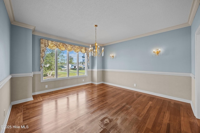 unfurnished dining area with wood finished floors, baseboards, a textured ceiling, and a chandelier