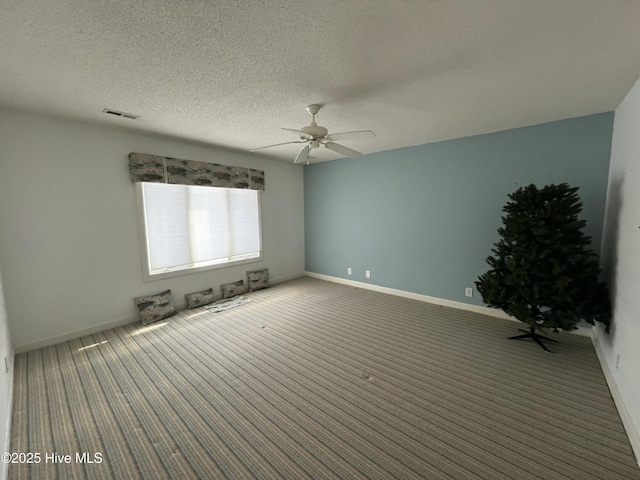 carpeted spare room with ceiling fan and a textured ceiling