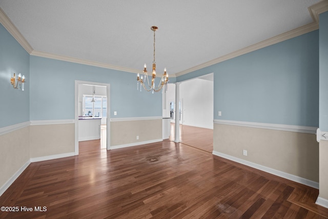 unfurnished dining area with crown molding, baseboards, an inviting chandelier, and wood finished floors