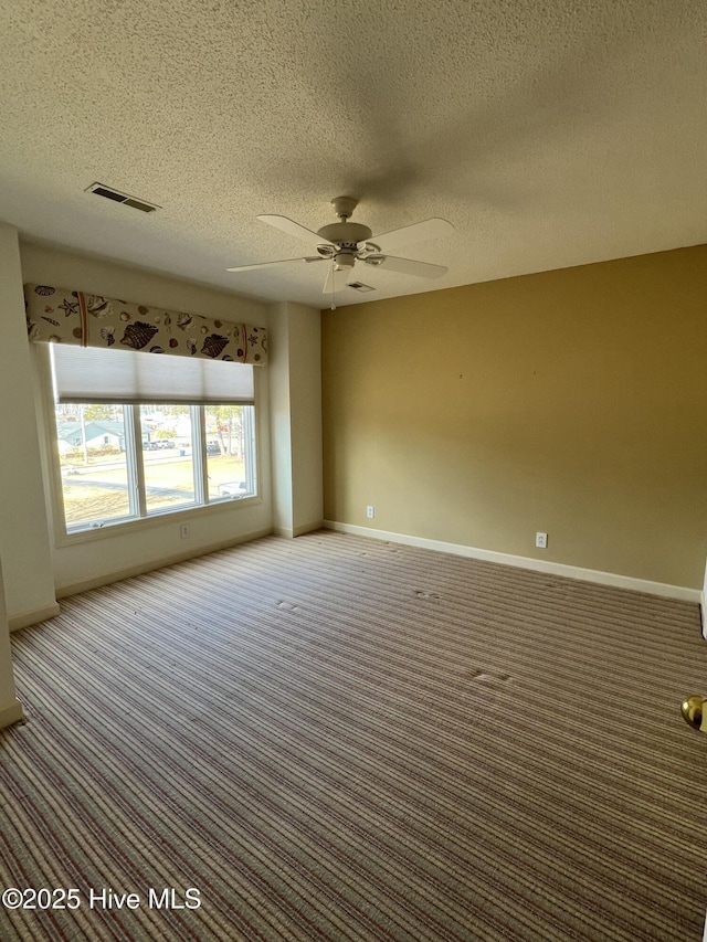 carpeted empty room featuring ceiling fan and a textured ceiling