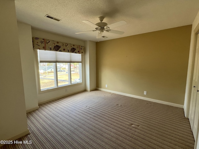 carpeted empty room with ceiling fan and a textured ceiling