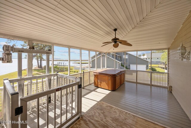 sunroom featuring a water view, a ceiling fan, and a jacuzzi