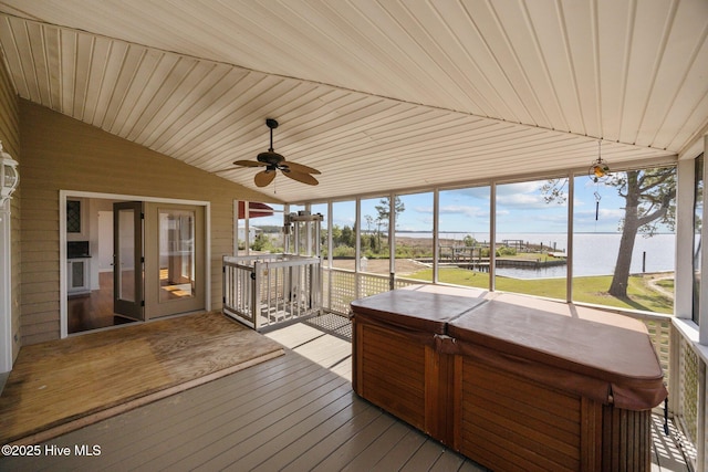 sunroom featuring a ceiling fan, a water view, and a hot tub
