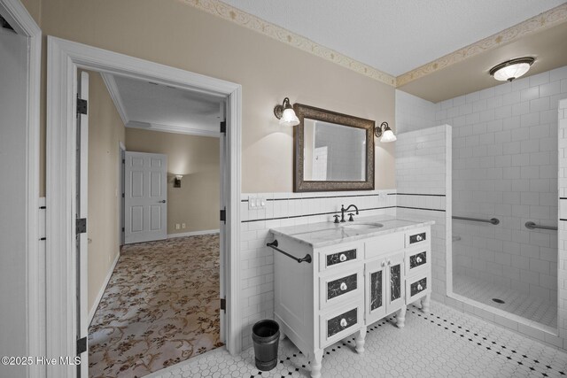 530 E St, Belhaven, NC 27810 - bathroom featuring crown molding, tile walls, a tile shower, vanity, and a wainscoted wall