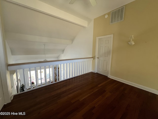 spare room with ceiling fan, dark hardwood / wood-style flooring, and vaulted ceiling with beams