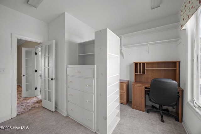 home office featuring baseboards, plenty of natural light, and french doors