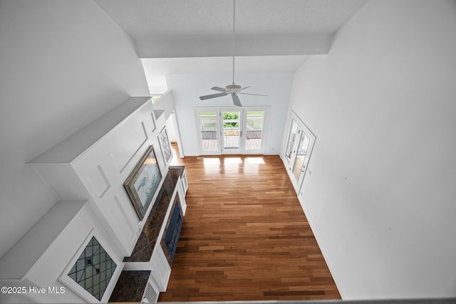 unfurnished living room featuring ceiling fan, a glass covered fireplace, and wood finished floors