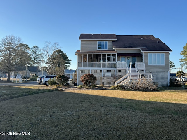 view of front of property featuring a front lawn and a sunroom