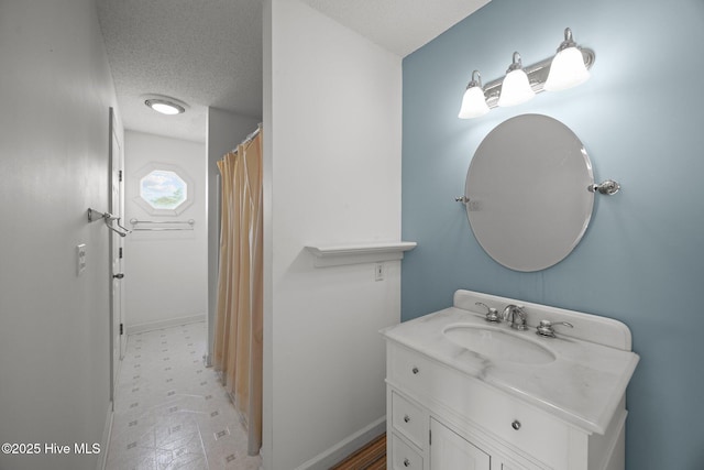 bathroom with vanity, tile patterned floors, a textured ceiling, and baseboards