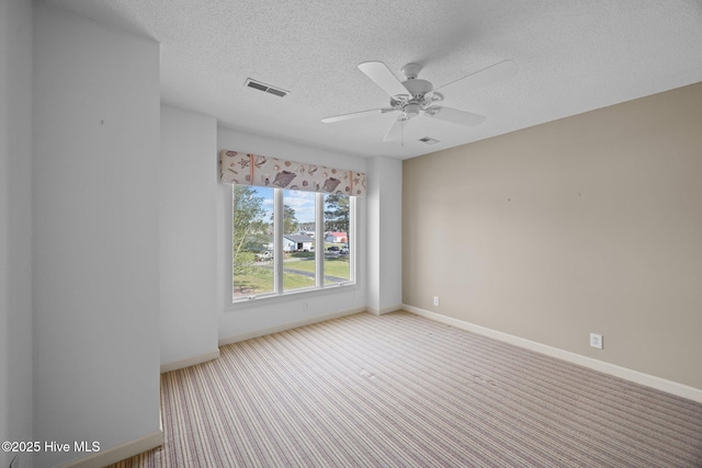 spare room with visible vents, baseboards, ceiling fan, a textured ceiling, and carpet flooring