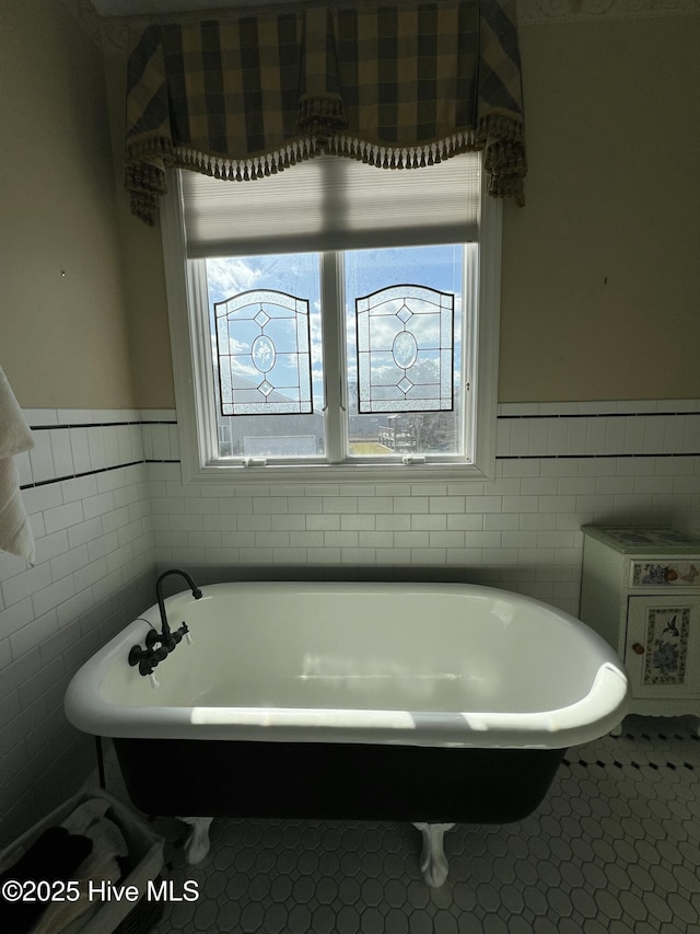 bathroom featuring tile walls, a bathtub, and tile patterned flooring