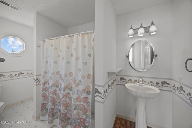 530 E St, Belhaven, NC 27810 - full bathroom featuring a textured ceiling, toilet, curtained shower, and visible vents