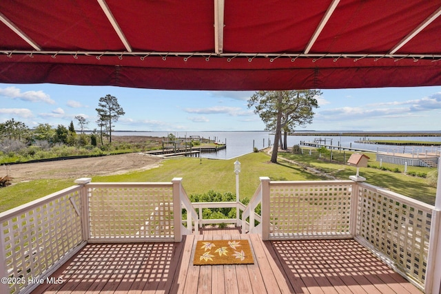 wooden deck with a yard and a water view