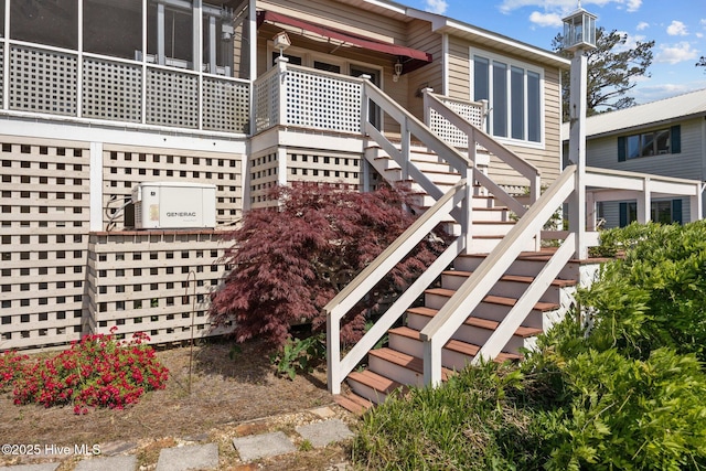 view of side of home featuring ac unit and stairway
