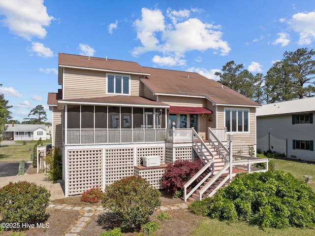 view of front of property with stairs and a sunroom