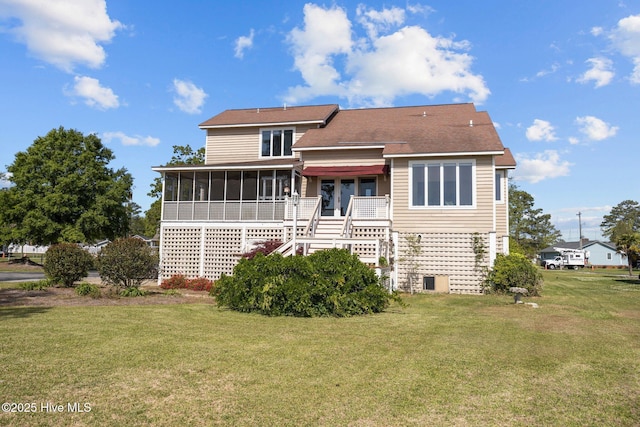 back of property with a yard, stairs, and a sunroom