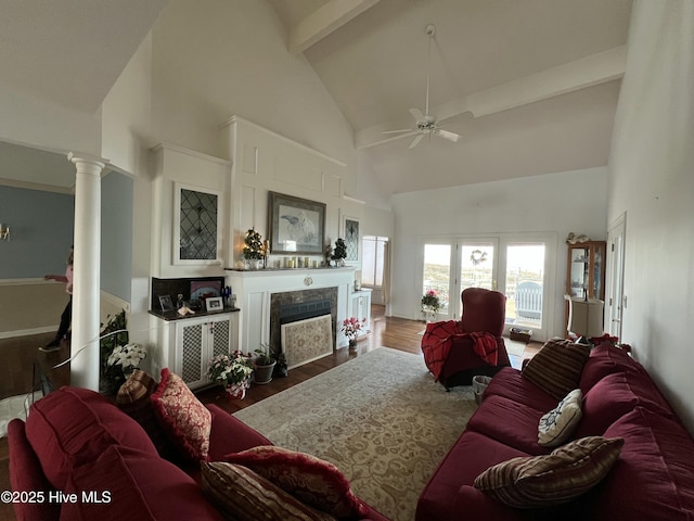 living room with hardwood / wood-style floors, a fireplace, decorative columns, high vaulted ceiling, and ceiling fan