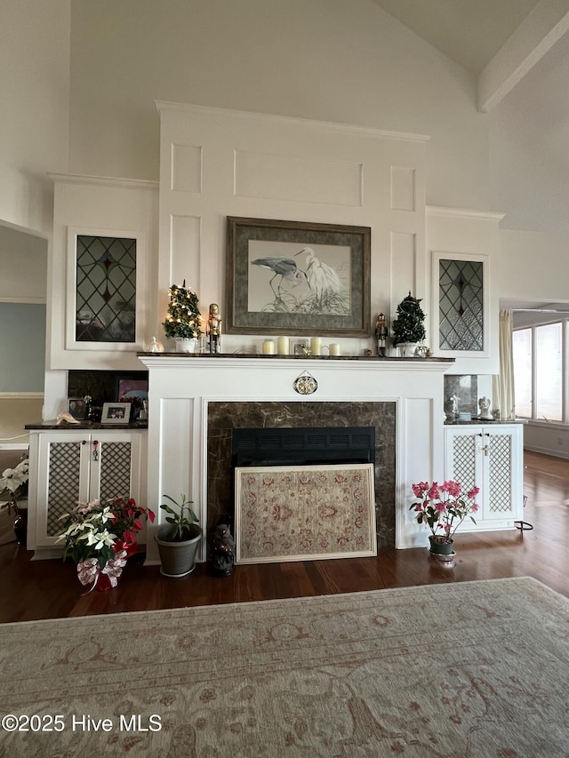 interior space featuring dark hardwood / wood-style floors, a high end fireplace, and vaulted ceiling