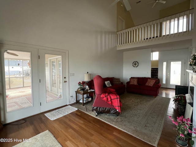 living room featuring ceiling fan, a high ceiling, and hardwood / wood-style floors