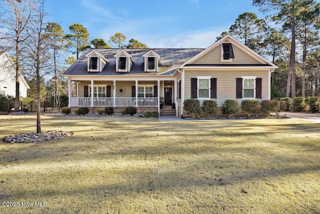 new england style home with covered porch and a front yard