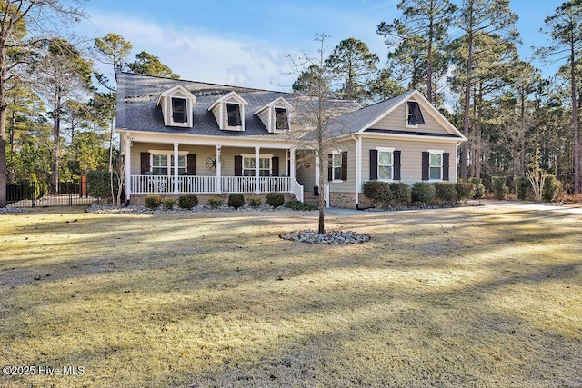 new england style home with a front yard and covered porch