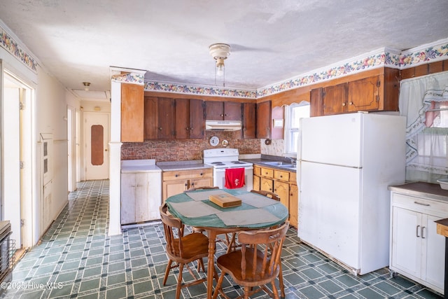 kitchen featuring plenty of natural light, white appliances, sink, and tasteful backsplash