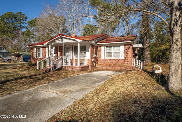 ranch-style home with a porch and a carport