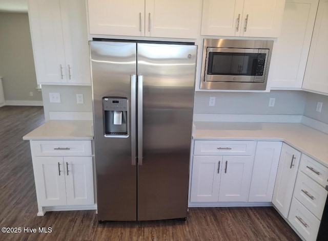 kitchen with dark hardwood / wood-style floors, appliances with stainless steel finishes, and white cabinets