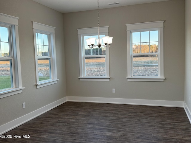 unfurnished dining area featuring dark hardwood / wood-style flooring and a chandelier