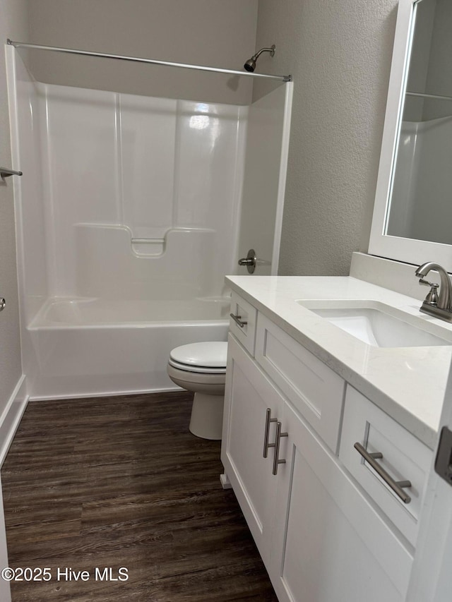 full bathroom featuring tub / shower combination, hardwood / wood-style floors, toilet, and vanity