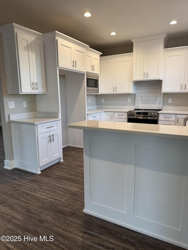 kitchen featuring backsplash, dark hardwood / wood-style flooring, stainless steel appliances, and white cabinetry